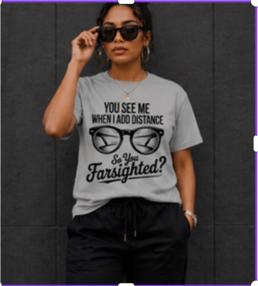 Person wearing a gray t-shirt with a humorous eyewear graphic and text.