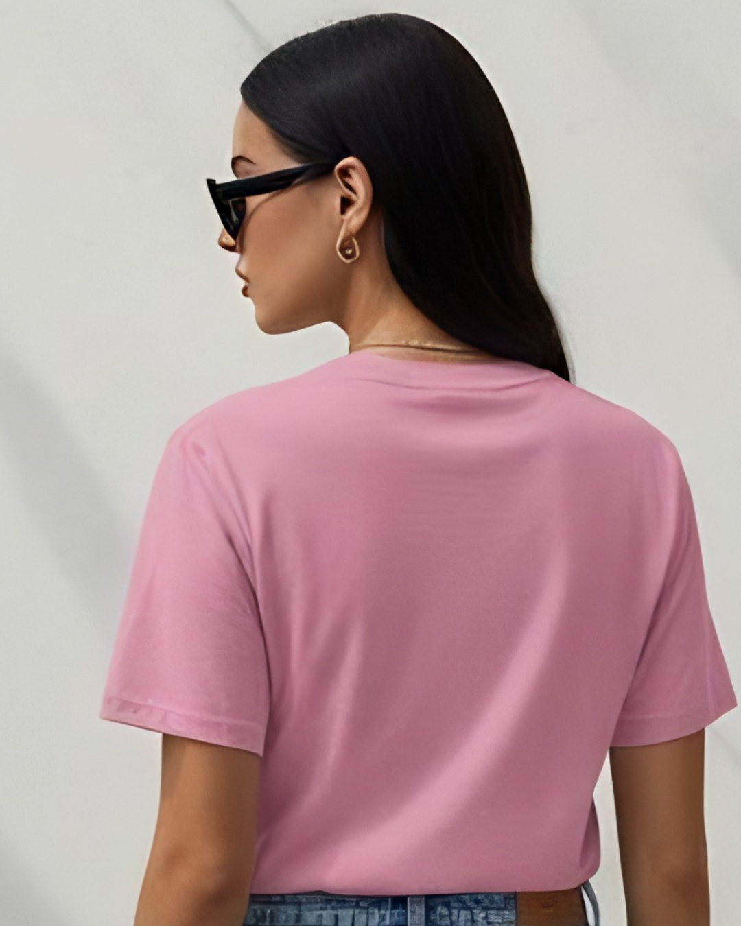 Person wearing a pink t-shirt from behind on a plain background