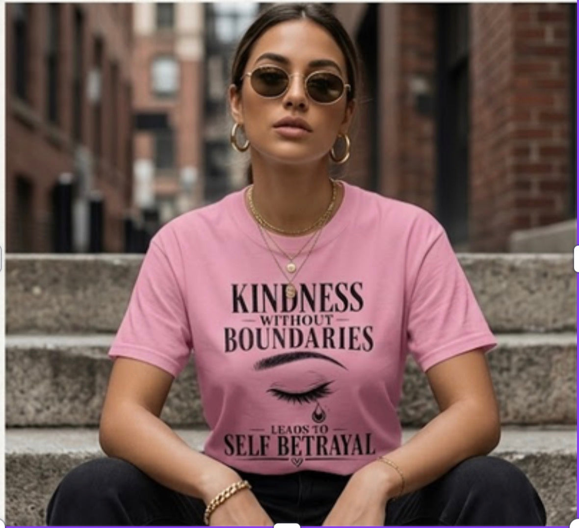 Woman wearing a pink t-shirt with a quote sitting on steps.