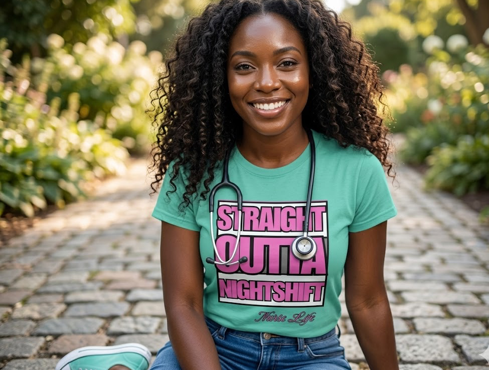 Woman wearing a green t-shirt with pink and white text, sitting outdoors on a stone path.